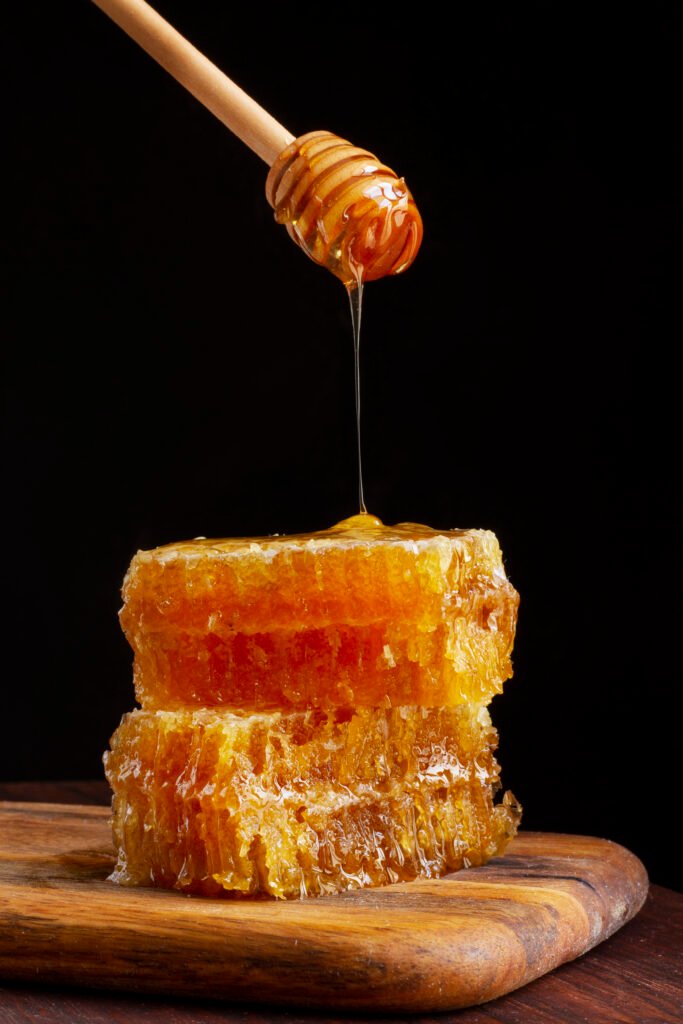front view honey dipper dripping honey honeycomb